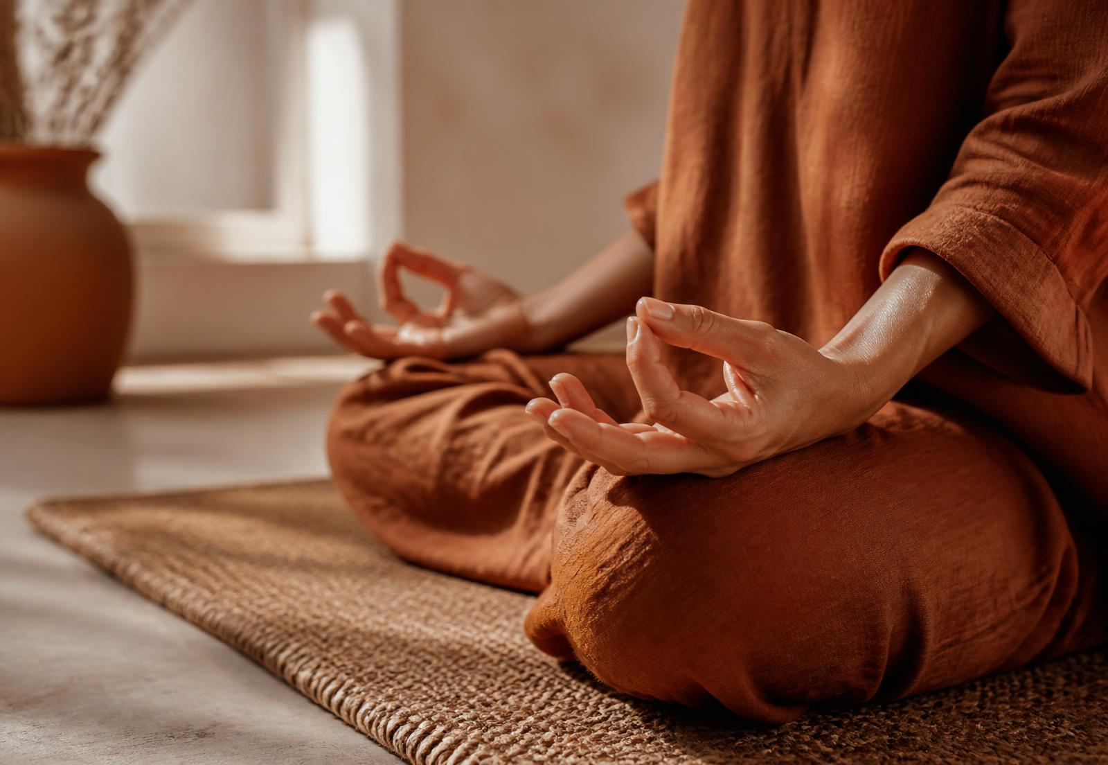 Mãos em meditação sobre tapete natural